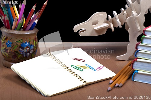 Image of Model of dinosaur, school board and pile books, notebook