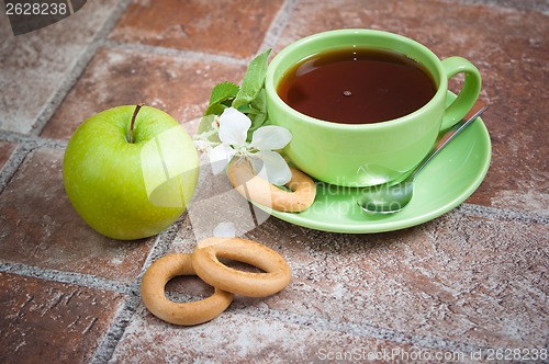 Image of Cup of tea with an apple