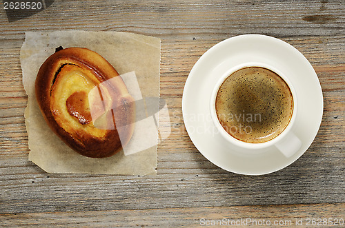 Image of cup of espresso and fresh bun 