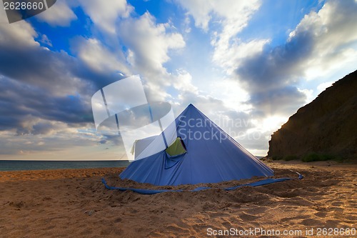 Image of Conical tent on summer beach and blue sky with clouds