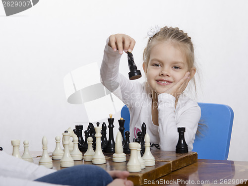Image of Girl playing chess in a good mood