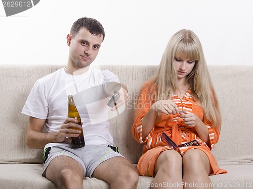 Image of He is watching TV with a beer, it handles nails nail file