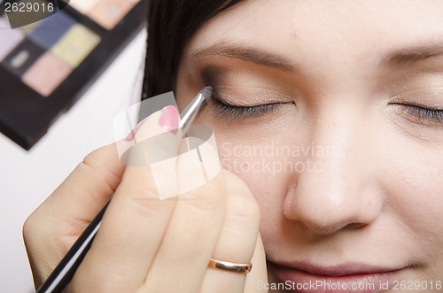 Image of Makeup artist colors upper eyelids model