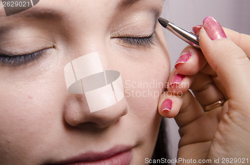 Image of Makeup artist colors upper eyelids model