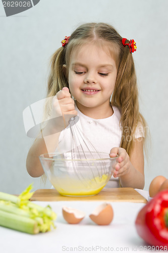 Image of Girl playing in a cook churn whisk eggs glass bowl