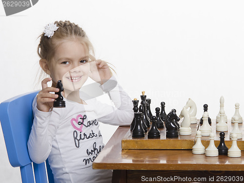 Image of Girl playing chess in a good mood