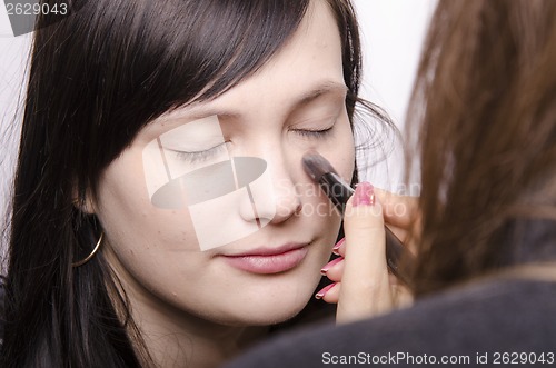 Image of Makeup artist deals powder on the face model