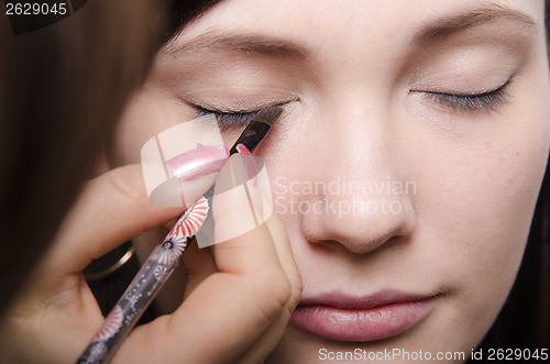 Image of Makeup artist colors eyelashes model