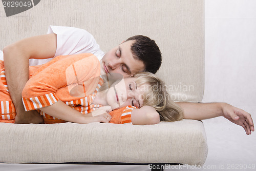 Image of Young couple sleeping on the couch
