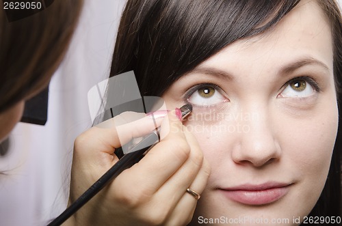 Image of Makeup artist colors eyelashes model