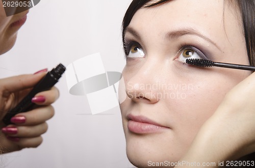 Image of Makeup artist colors eyelashes model