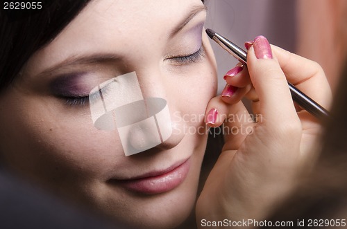 Image of Makeup artist colors upper eyelids model