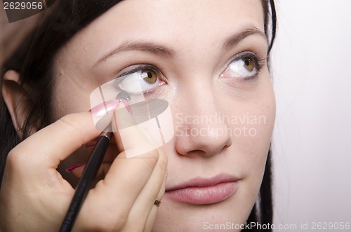 Image of Makeup artist colors eyelashes model