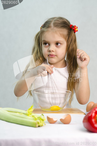 Image of Girl playing in a cook churn whisk eggs glass bowl