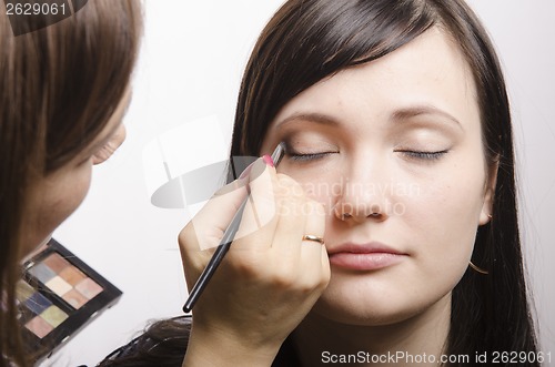 Image of Makeup artist colors upper eyelids model