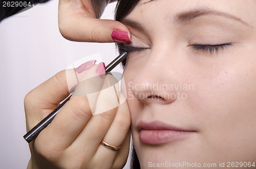 Image of Makeup artist colors eyelashes model