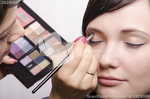 Image of Makeup artist colors upper eyelids model