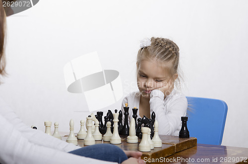 Image of Girl playing chess in a good mood