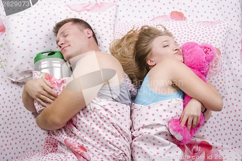 Image of husband sleeps barrel of beer, wife with soft toy