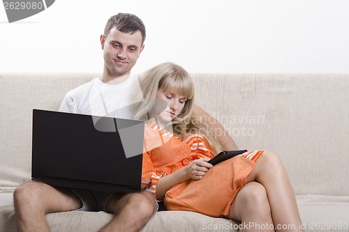 Image of Guy and girl asleep, sitting on couch with laptop