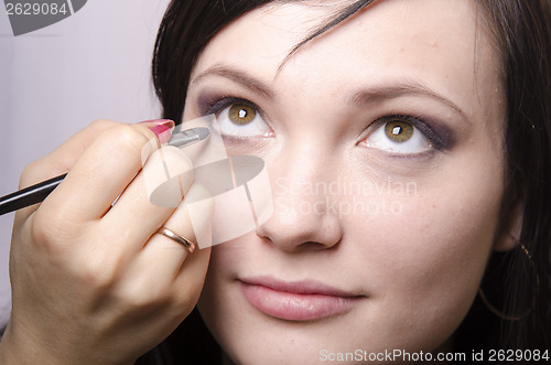 Image of Makeup artist colors eyelashes model