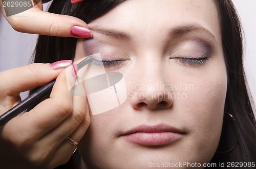 Image of Makeup artist colors upper eyelids model