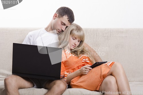 Image of Guy and girl asleep, sitting on couch with laptop