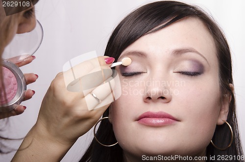 Image of Makeup artist colors upper eyelids model