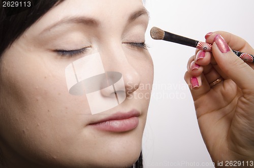 Image of Makeup artist colors upper eyelids model