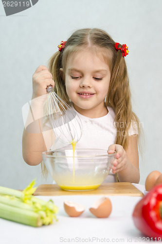 Image of Girl playing in a cook churn whisk eggs glass bowl