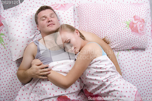 Image of Young couple sleeping in bed