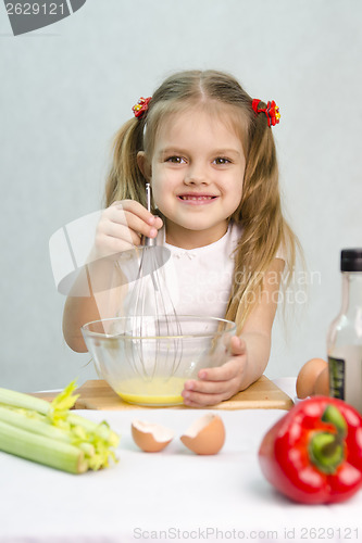 Image of Girl playing in a cook churn whisk eggs glass bowl