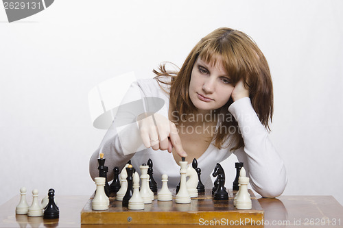Image of Young girl to be considering a move during the game of chess