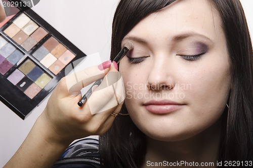 Image of Makeup artist colors upper eyelids model