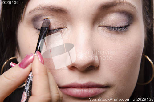 Image of Makeup artist colors upper eyelids model