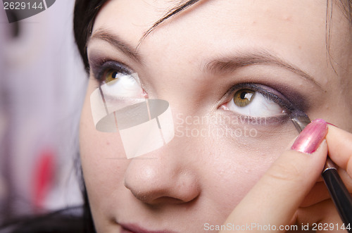 Image of Makeup artist colors eyelashes model