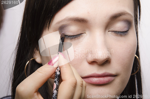 Image of Makeup artist colors upper eyelids model