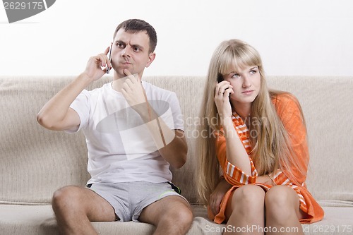 Image of young couple phone sitting on couch
