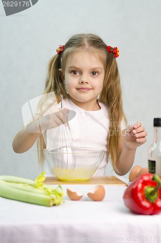 Image of Girl playing in a cook churn whisk eggs glass bowl