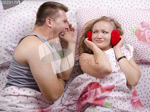 Image of The guy is yelling at girl lying in bed