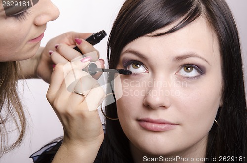 Image of Makeup artist colors eyelashes model