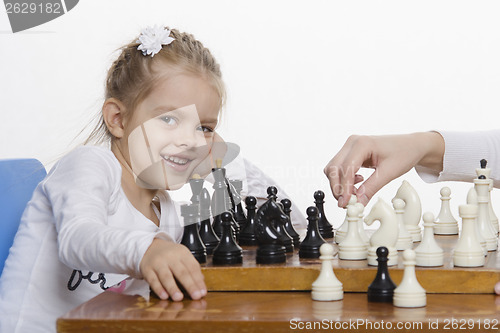 Image of Girl playing chess in a good mood