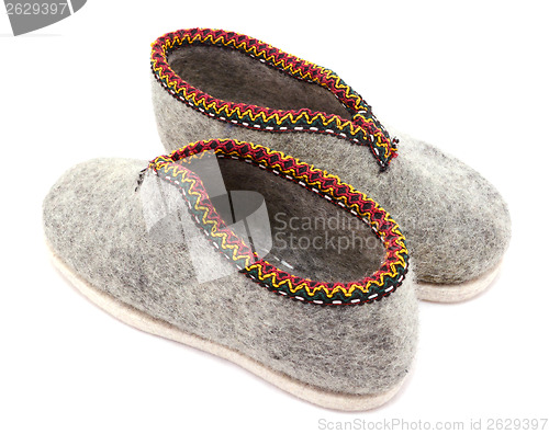 Image of Two traditional grey felt slippers posed heel to toe