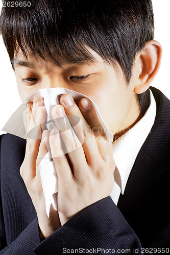 Image of Young Man Blowing Nose into a tissue 