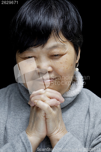 Image of Asian woman praying and praising the Lord 