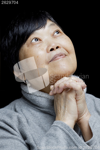 Image of Asian woman praying and praising the Lord 