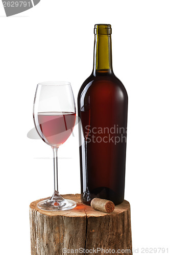 Image of Glass of red wine and bottle on stump isolated on white