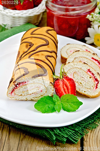 Image of Roulade with jam and strawberries on a board