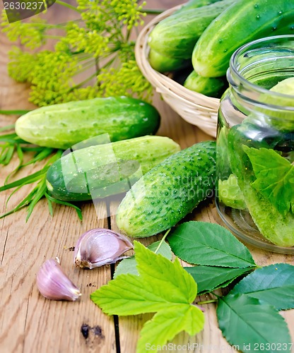 Image of Cucumbers in jar and a wicker basket with leaves