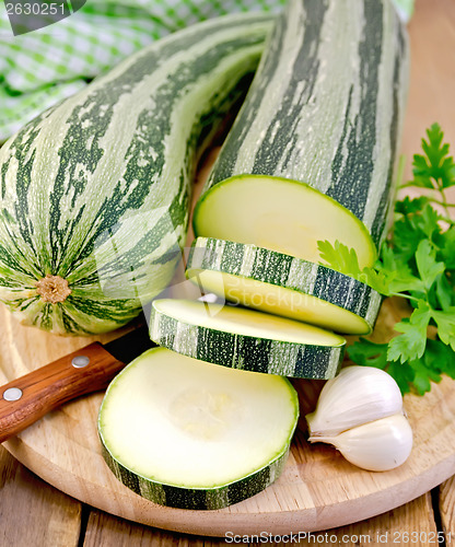 Image of Zucchini green striped with a knife on board